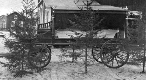 Inför Fride Nygård (10.8.1919–29.3.1933) sista färd i likvagn. Han var son till Axel och Lovisa Nygård och dog i lunginflammation. Axel och Ida Lunds hus i bakgrunden.