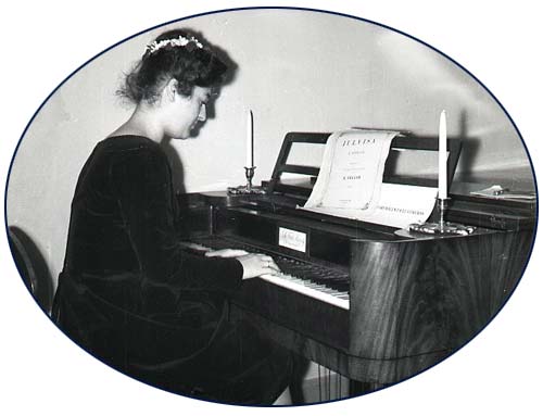 En okänd dam spelar i början av 1960-talet på klavikordet vid Kuddnäs. I notstället finns Julvisa av Topelius.