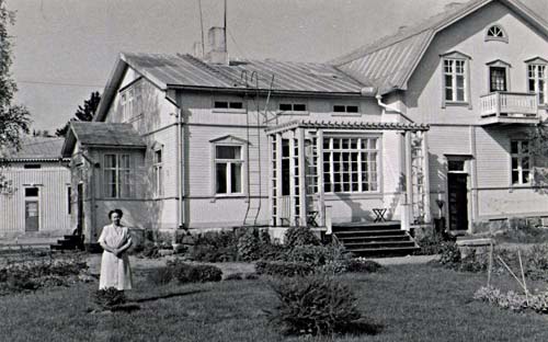 Grannen Agnes Fagerholm, kassörska vid Alko som fanns i huset på andra sidan Borgaregatan, poserar i trädgården.